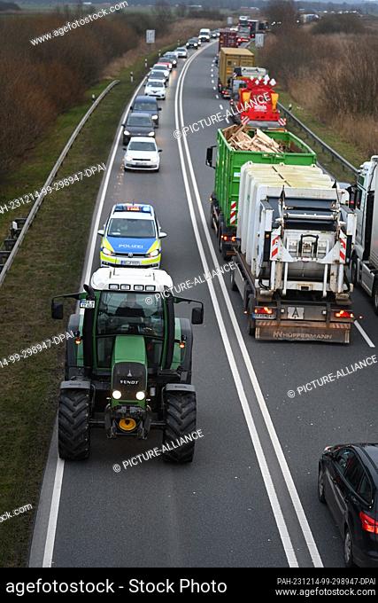 14 December 2023, Bremen, Wesermarsch: Farmers protest and drive their tractors near the Weser tunnel. There is currently a traffic jam in the area of the Weser...