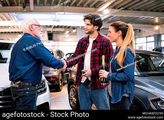 Couple buying new car at car dealership