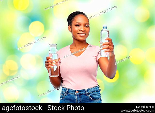 happy woman with plastic and glass bottle of water