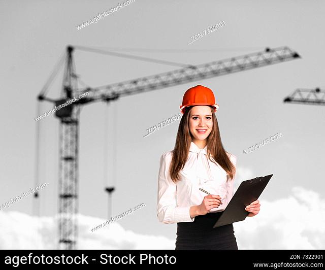 Smiling woman in hardhat on the building side