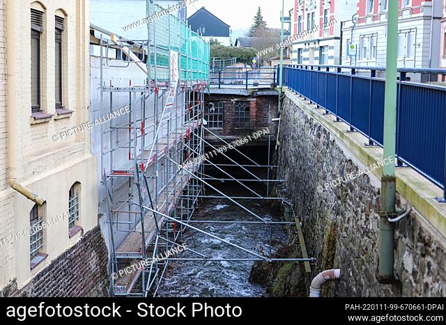 11 January 2022, North Rhine-Westphalia, Hagen: Half a year after flood damage to a building, scaffolding stands on the wall that collapsed