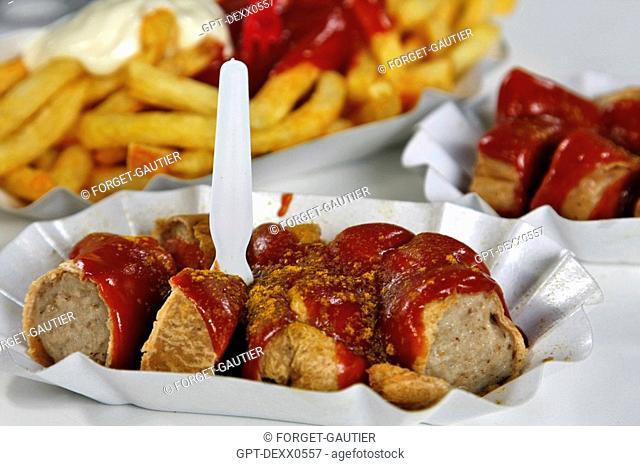 SEASONED CURRYWURST SAUSAGE IN CURRY, A TRADITIONAL DISH IN TOMATO SAUCE WITH CAYENNE PEPPER AND CURRY POWDER, BERLIN, GERMANY