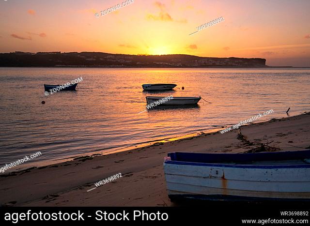 Fishing boats on a river sea at sunset in Foz do Arelho, Portugal