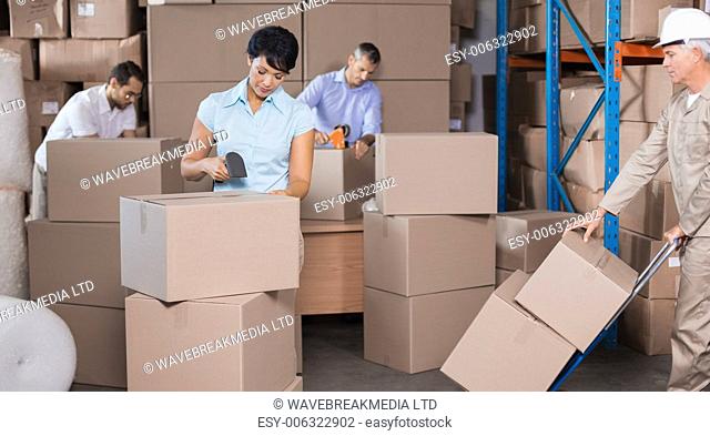 Warehouse workers preparing a shipment in a large warehouse