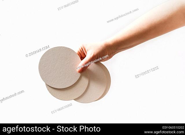 Female hand holding a blank beer coasters