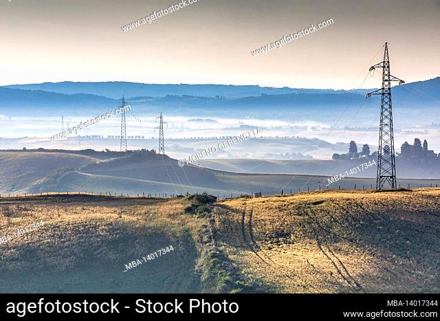 tuscan hills crossed by a high voltage electricity line, asciano, province of siena, tuscany, italy
