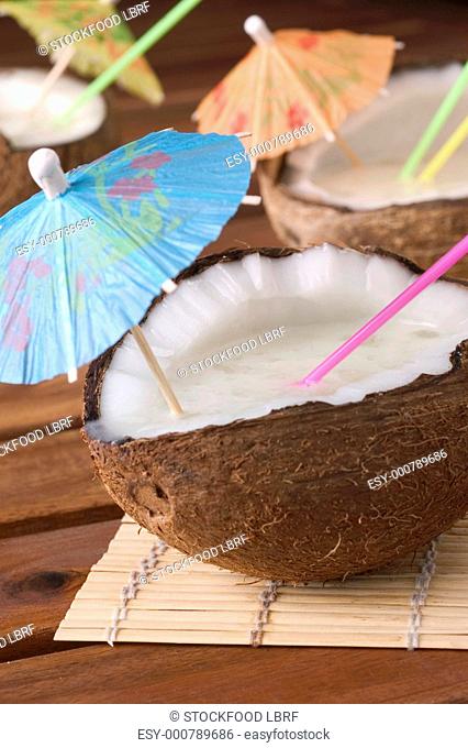 Pina Colada with cocktail umbrellas in coconut halves