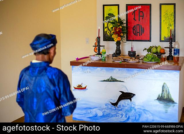 PRODUCTION - 02 March 2021, Vietnam, Tam Hai: A believer prays in front of an altar with an image of a whale during the Whale Worship Festival in Tam Hai