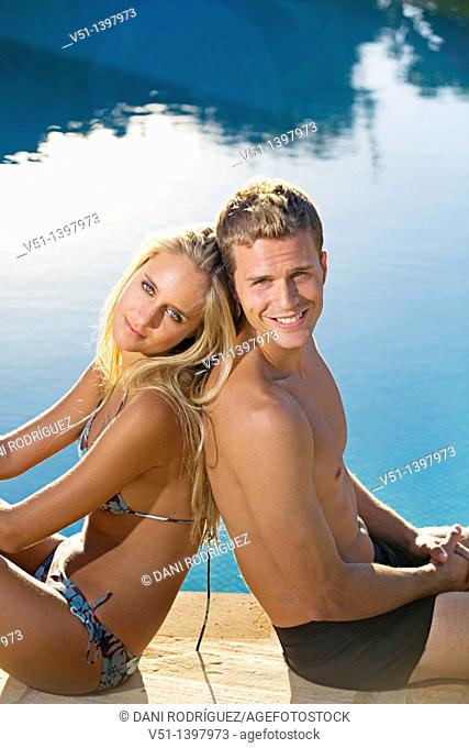 Portrait of a beautiful couple sitting by the pool
