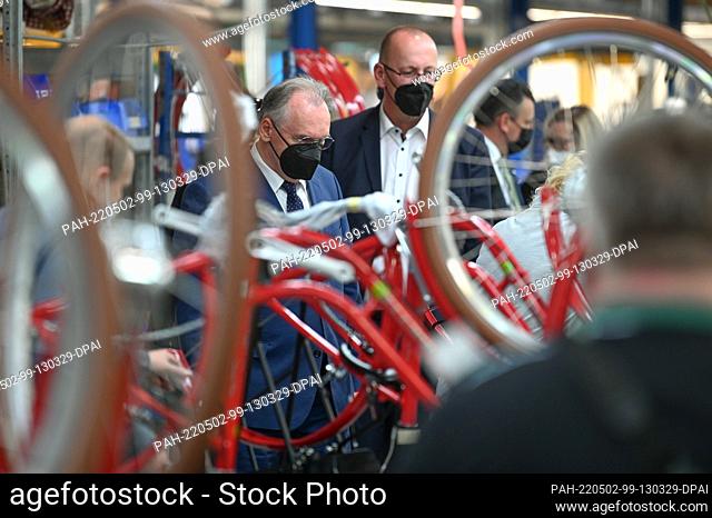 01 May 2022, Saxony-Anhalt, Sangerhausen: On the assembly line for e-bikes, Saxony-Anhalt's Minister President Reiner Haseloff (CDU) inspects final assembly