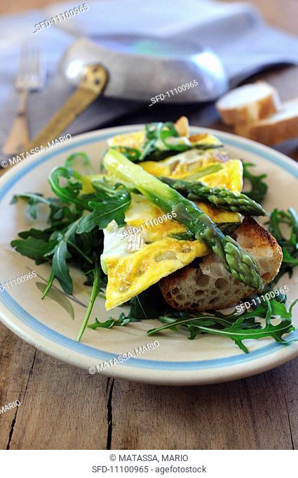 Goats cheese and asparagus omelette on bruschetta with rocket leaves