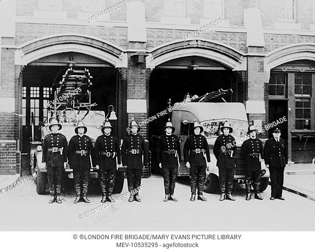 The crew of Woolwich fire station parade in Sunbury Street on the station forecourt. WWII is pending and an Auxiliary Fire Service fire engine is standing in...