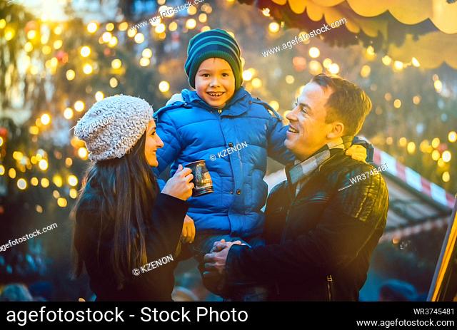Family having fun on Christmas market, dad holding his son