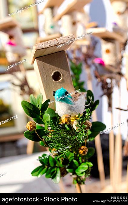 small decoration wooden bird house box and little colorful handmade bird shape figure sold in outdoor spring easter fair market