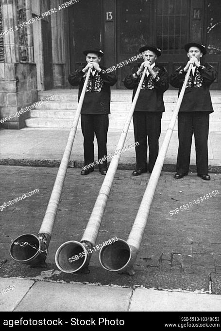 Blowing Their Own Trumpets! -- Swiss mountaineers demonstrating their skill on the 12 feet long wooden alp-horns.The men are among the 145 Swiss men and women...