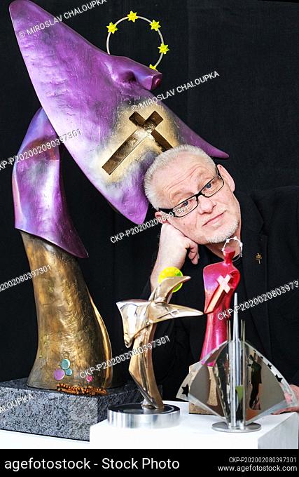 Czech sculptor Vaclav Cesak poses with one of three statuettes of St John of Nepomuk, center, on February 8, 2020, in Novy Smolivec, Czech Republic