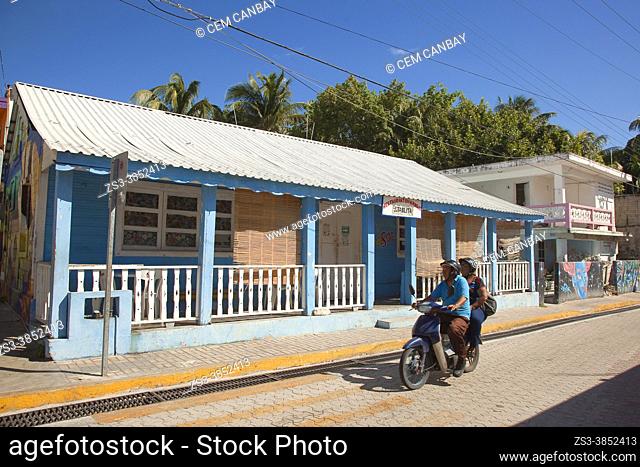 Motorcyclist in front of a colonial building at the town center, Isla Mujeres, Cancun, Quintana Roo, Mexico, Central America