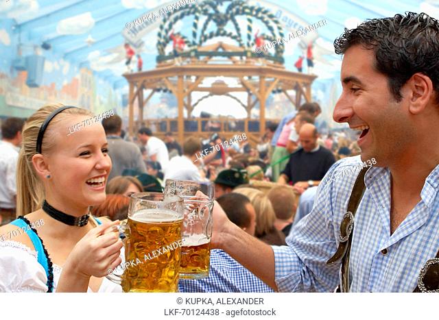 Young couple drinking beer during Oktoberfest, Munich, Bavaria, Germany
