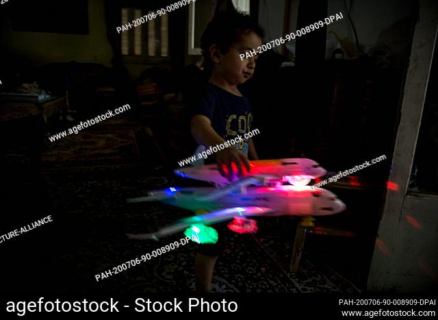 18 June 2020, Egypt, Cairo: Mohamed Ahmed, 3 years old, plays with a toy in the shape of a plane. Mohamed, his sister and his mother were supposed to travel to...