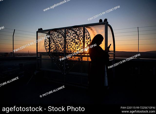 15 January 2022, Slovakia, Bratislava: A woman stands on the platform of the Ufo observation tower and looks at her smartphone