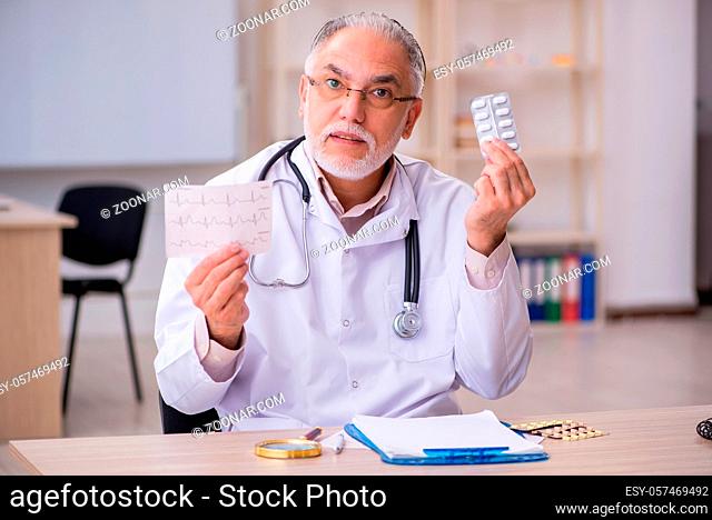 Old doctor cardiologist working in the clinic
