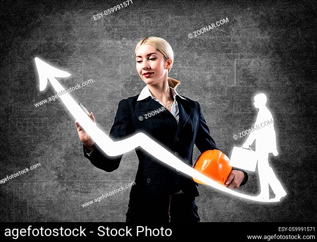 Business lady drawing success graph. Development of successful professional career. HR specialist in business suit with safety helmet