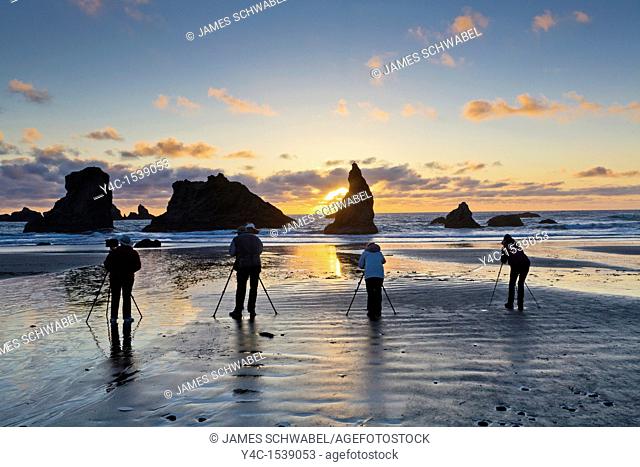 Photographers at sunset in Oregon Islands National Wildlife Refuge, Coquille Point Unit also called Bandon Beach on the Pacific coast in Bandon Oregon