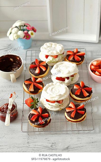 Chocolate sandwich biscuits with strawberry jam, and mini pavlovas with lime whipped cream and strawberries