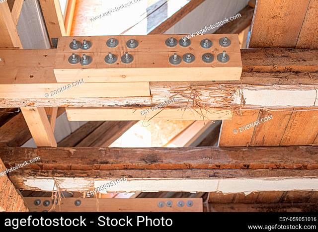 in laborious work an old house is restored, whereby old beams are strengthened with new ones