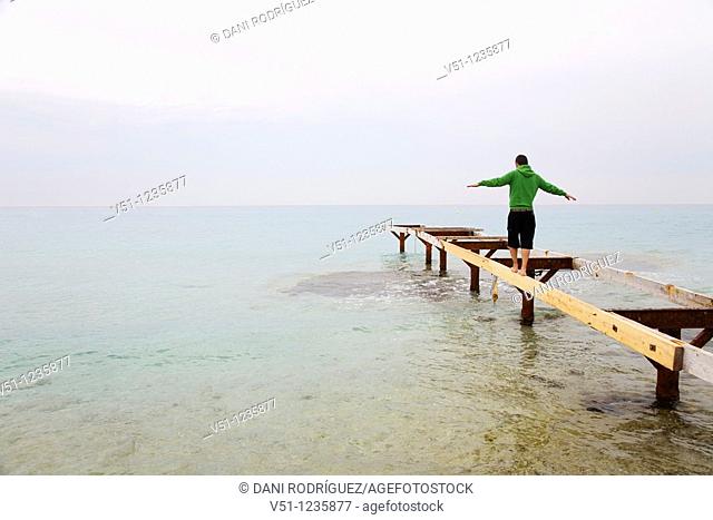Man doing balance in a pier in Formentera
