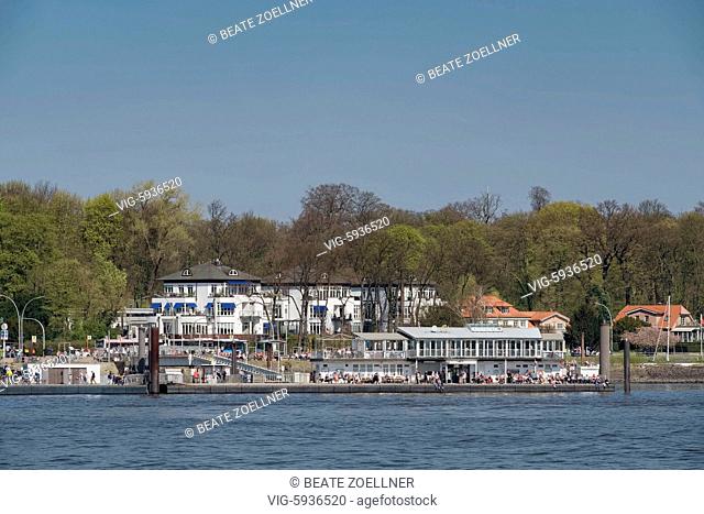 Blick von Hamburg-Finkenwerder über die Elbe auf den Anleger mit dem Café Engel in Teufelsbrück an der Elbchaussee. Viele Menschen genießen den sonnigen...