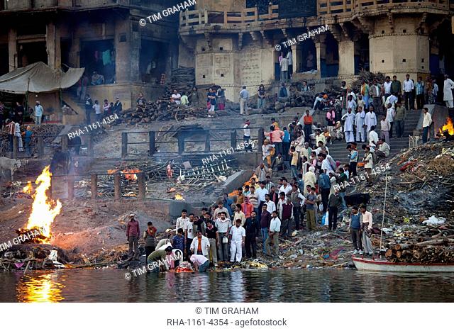 Body bathed in River Ganges and traditional Hindu cremation on funeral pyre at Manikarnika Ghat in Holy City of Varanasi, Benares, India