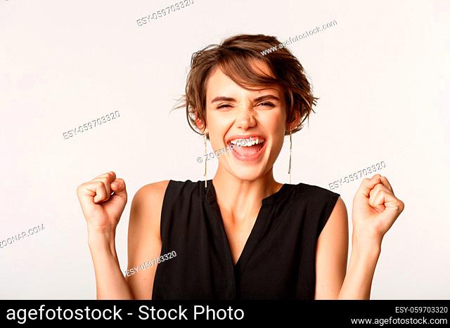 Close-up of ambitious businesswoman triumphing, winning and screaming ecstatic