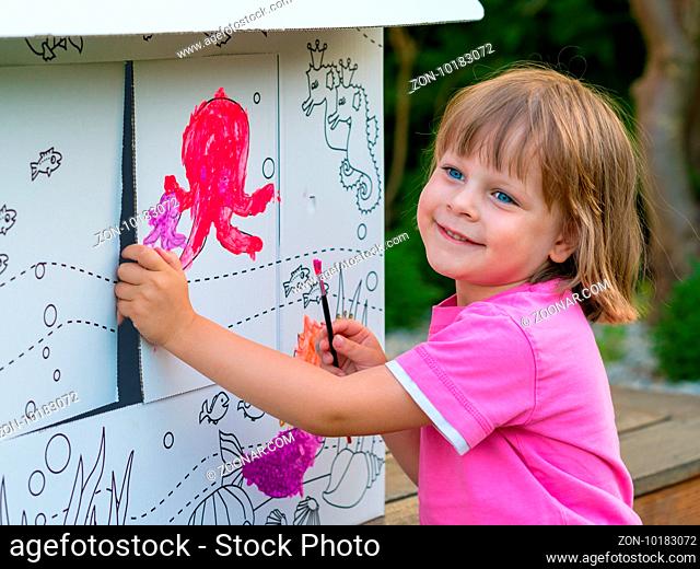 Young Girl Painting Cardboard House In the Garden