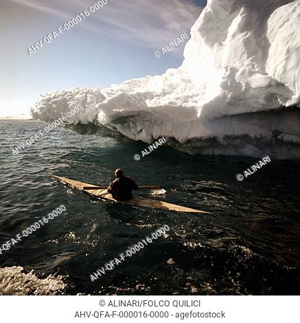 An Eskimo and his waterproof kayak, skirting an ice cliff near Attu, Disko Bay, Greenland, shot 1976 by Quilici, Folco