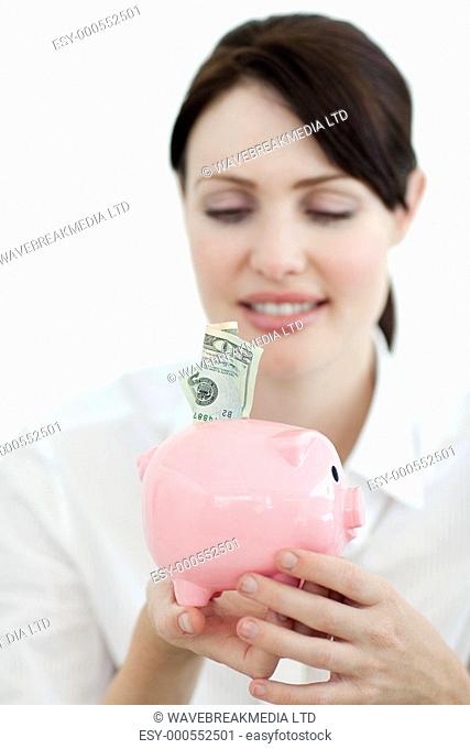 Young businesswoman saving money in a piggybank isolated on a white background
