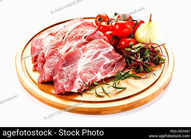 Raw pork chops on cutting board and vegetable
