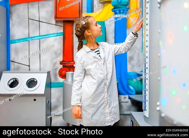 Little child in uniform playing doctor in laboratory, playroom. Kid plays medicine worker in imaginary hospital lab, profession learning, childish dream