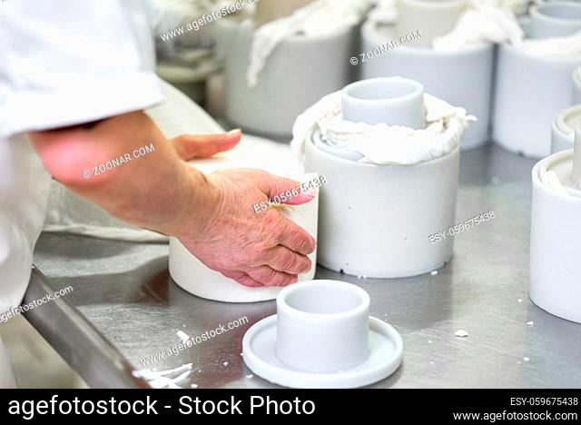 Cheese production industry. workers close up preparing cheese raw dough into molds