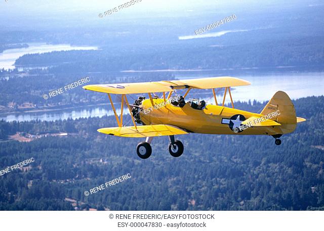 1944 Boeing Stearman PT-17 biplane flying over Puget Sound. Washington. USA
