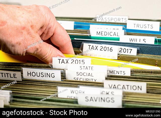 Close up of a well organized home filing system with tabs for each subject and focus on tax return papers