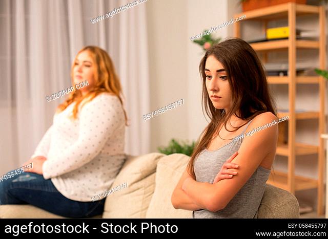 Two female patients in bad mood sittin on sofa at dietitian office