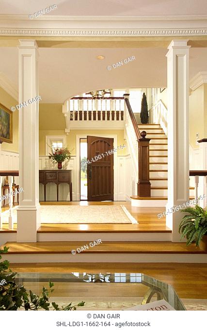 Foyer of traditional home with staircase and pillars