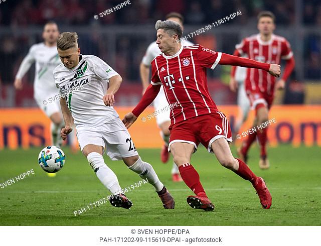 Robert Lewandowski (r) of Munich and Matthias Ostrzolek of Hannover vie for the ball during the German Bundesliga football match between Bayern Munich and...