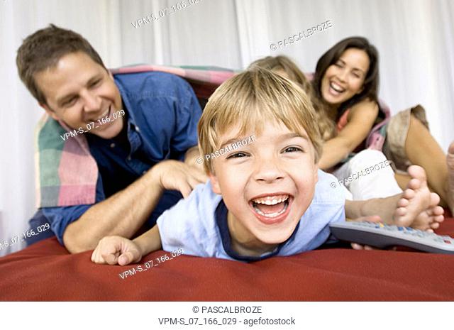Parents tickling their son and daughter