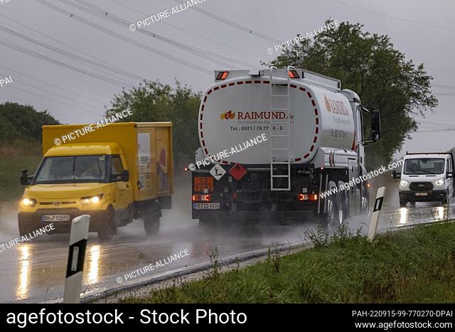 15 September 2022, Bavaria, Forchheim: A Deutsche Post electric car and a heating oil transporter drive past each other. Forchheim