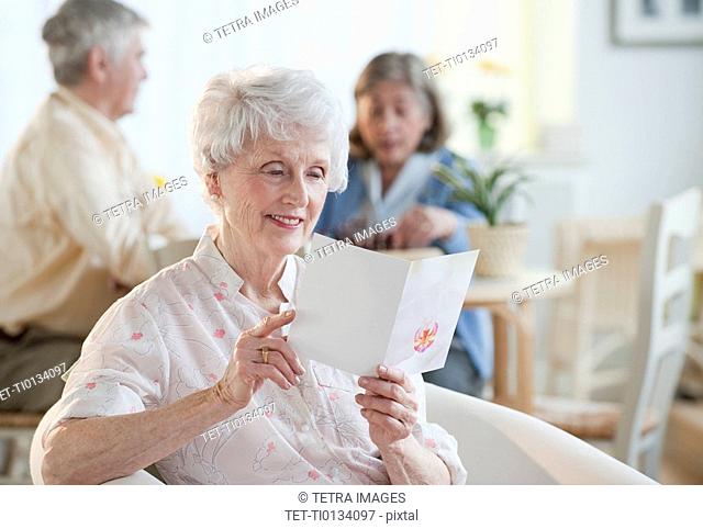 Senior woman reading greeting card