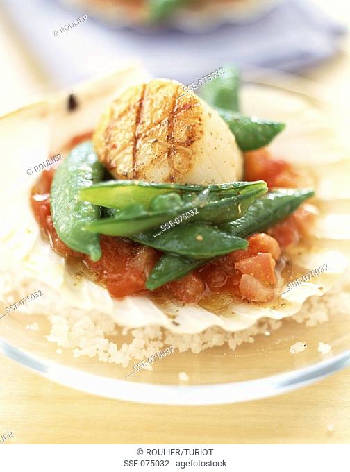Scallops with peas with their pods and crushed tomatoes