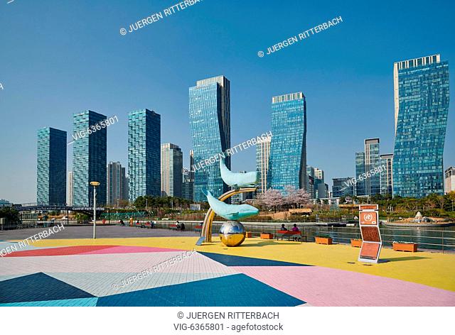 SOUTH KOREA, INCHEON CITY, 19.04.2019, whale figures in Central Park of Songdo International Business District with skyscraper in the back, Incheon City