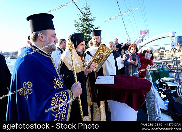 08 January 2023, Hamburg: Auxiliary Bishop Bartholomaios Kessidis of Arianz (2nd from left) during the ceremony next to Archpriest Georgios Manos (l) and...